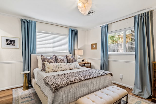 7805 Eagle Trl, Dallas, TX 75238 - bedroom featuring wood finished floors, wainscoting, crown molding, and a decorative wall