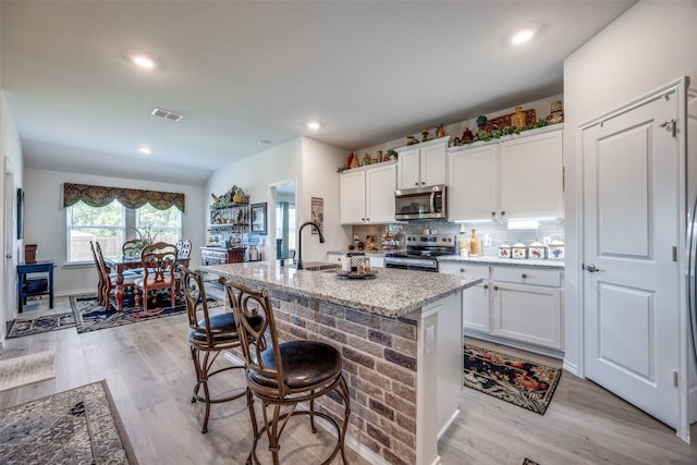 525 Brandy Ln, Tom Bean, TX 75489 - kitchen featuring appliances with stainless steel finishes, an island with sink, white cabinets, light stone counters, and recessed lighting