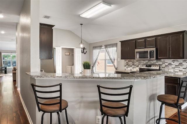 1433 Wind Dancer Trl, Fort Worth, TX 76131 - kitchen featuring appliances with stainless steel finishes, dark wood-style flooring, dark brown cabinets, lofted ceiling, and baseboards