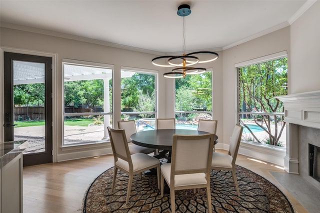 805 Cross Ln, Southlake, TX 76092 - dining area with light wood-type flooring, a premium fireplace, a chandelier, and ornamental molding