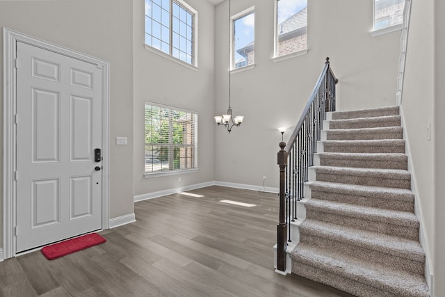 7913 Heritage Palms Trl, Mckinney, TX 75070 - entrance foyer featuring a chandelier, stairs, wood finished floors, a high ceiling, and baseboards