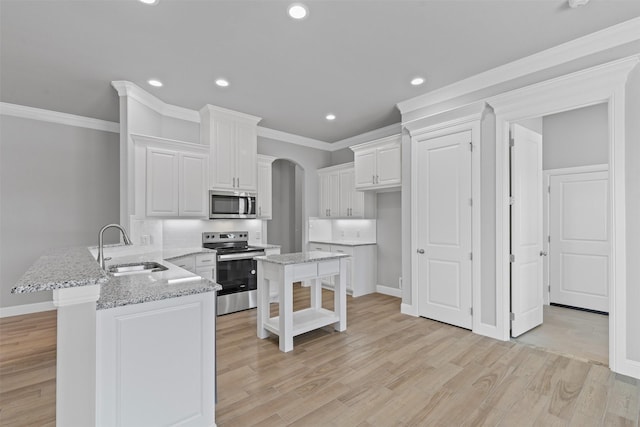 833 Haley, Springtown, TX 76082 - kitchen featuring appliances with stainless steel finishes, a sink, a peninsula, ornamental molding, and white cabinetry