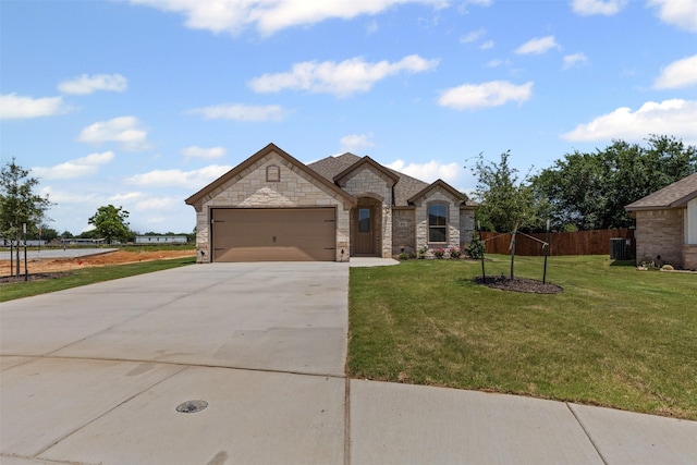 833 Haley, Springtown, TX 76082 - french country inspired facade with concrete driveway, a garage, central AC unit, and stone siding