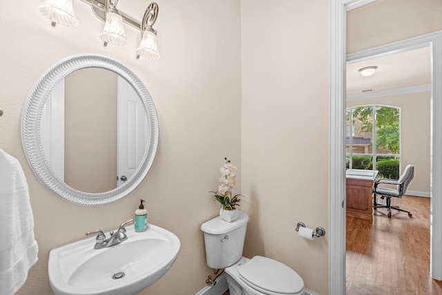 15372 Mountain View Ln, Frisco, TX 75035 - half bath with a sink, toilet, wood finished floors, baseboards, and crown molding