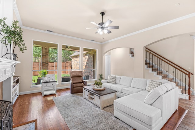 15372 Mountain View Ln, Frisco, TX 75035 - living room with arched walkways, a ceiling fan, wood finished floors, stairs, and crown molding