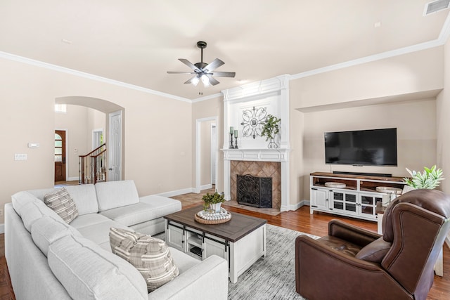 15372 Mountain View Ln, Frisco, TX 75035 - living room with arched walkways, a ceiling fan, wood finished floors, crown molding, and a fireplace