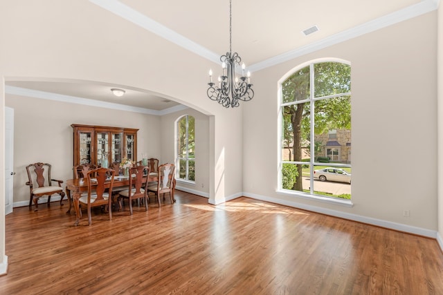 15372 Mountain View Ln, Frisco, TX 75035 - dining area featuring arched walkways, wood finished floors, crown molding, a chandelier, and baseboards