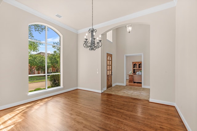 15372 Mountain View Ln, Frisco, TX 75035 - unfurnished room featuring a chandelier, wood finished floors, ornamental molding, arched walkways, and baseboards