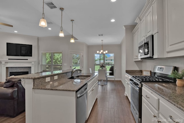 2087 Sand Crest Dr, Shreveport, LA 71118 - kitchen featuring appliances with stainless steel finishes, a sink, open floor plan, a fireplace, and plenty of natural light