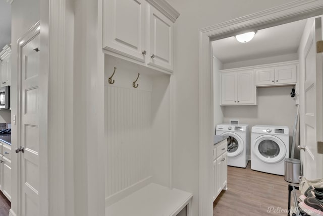 2087 Sand Crest Dr, Shreveport, LA 71118 - laundry area featuring light wood finished floors, cabinet space, and washer and dryer