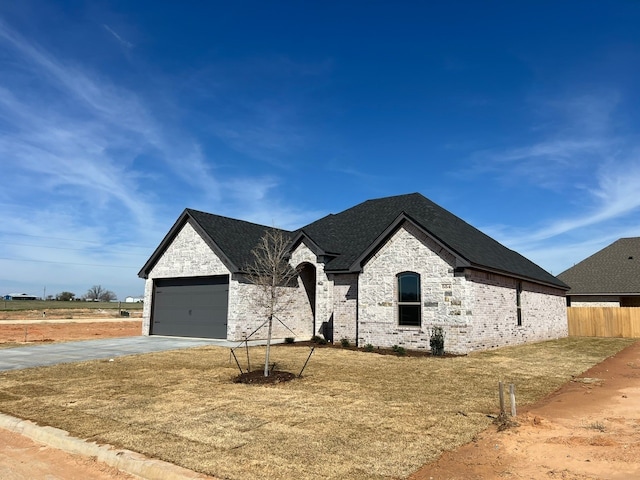 554 Calla Lily Dr, Tolar, TX 76476 - french provincial home featuring concrete driveway, brick siding, an attached garage, and stone siding
