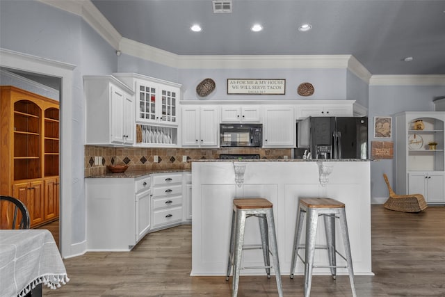 10513 Rayburn Way, Waco, TX 76708 - kitchen featuring black appliances, white cabinets, a kitchen breakfast bar, backsplash, and dark stone counters