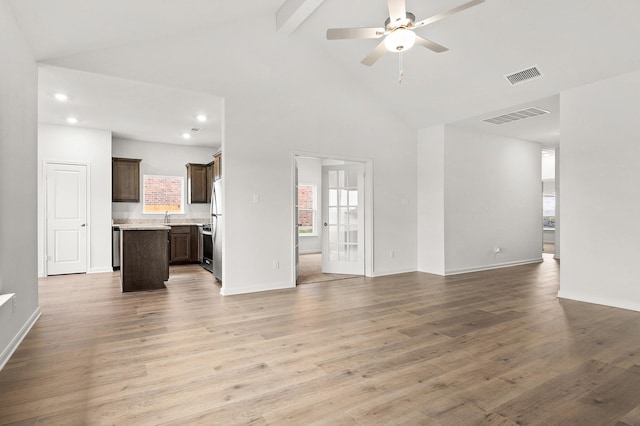 409 Gib Woodall Dr, Venus, TX 76084 - unfurnished living room featuring beam ceiling, a ceiling fan, high vaulted ceiling, baseboards, and light wood finished floors