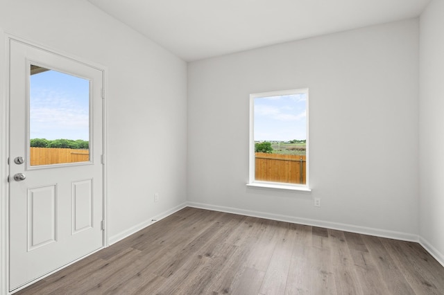 409 Gib Woodall Dr, Venus, TX 76084 - empty room featuring healthy amount of natural light, light wood finished floors, and baseboards