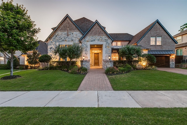 4540 Honeyvine Ln, Prosper, TX 75078 - french country inspired facade featuring stone siding, a standing seam roof, a lawn, and a garage