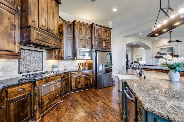 4540 Honeyvine Ln, Prosper, TX 75078 - kitchen with stainless steel appliances, a warming drawer, dark stone countertops, ceiling fan, and dark wood-style floors