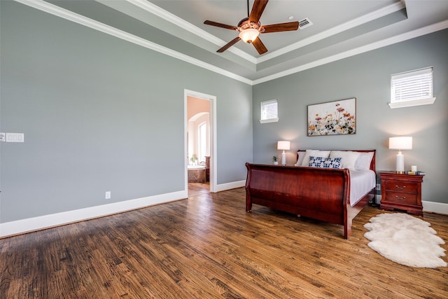 4540 Honeyvine Ln, Prosper, TX 75078 - bedroom with wood finished floors, baseboards, a tray ceiling, arched walkways, and crown molding