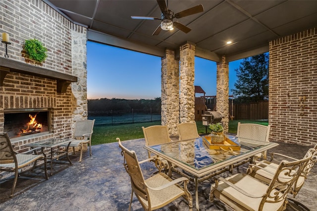 4540 Honeyvine Ln, Prosper, TX 75078 - fenced backyard featuring an outdoor brick fireplace, outdoor dining space, a ceiling fan, a patio, and grilling area