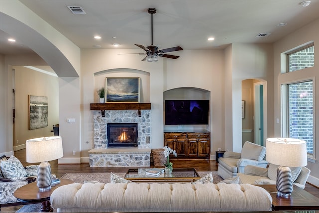 4540 Honeyvine Ln, Prosper, TX 75078 - living area featuring arched walkways, wood finished floors, a ceiling fan, a fireplace, and baseboards