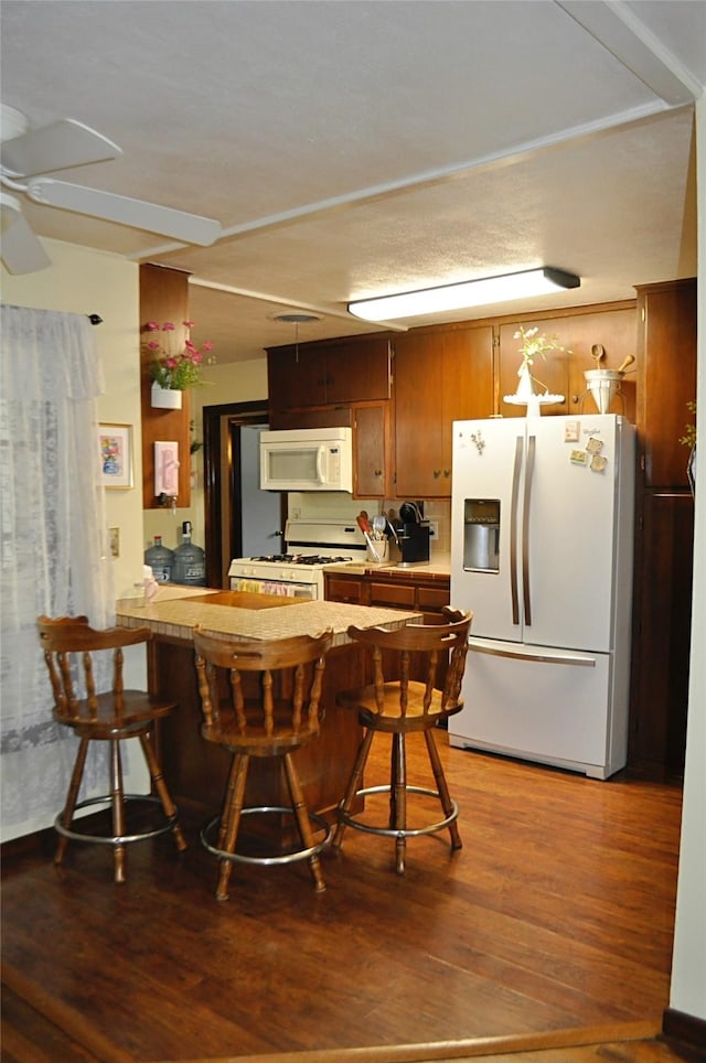 1405 Rolling Hills Dr, Graham, TX 76450 - kitchen featuring white appliances, light wood-type flooring, a peninsula, ceiling fan, and light countertops