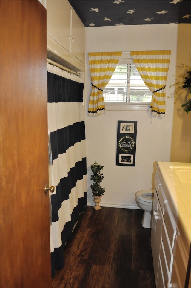 1405 Rolling Hills Dr, Graham, TX 76450 - bathroom with vanity, toilet, wood finished floors, and a shower with shower curtain
