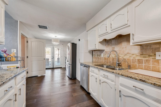 921 Granite Ln, Desoto, TX 75115 - kitchen with appliances with stainless steel finishes, a sink, white cabinets, tasteful backsplash, and dark wood-type flooring