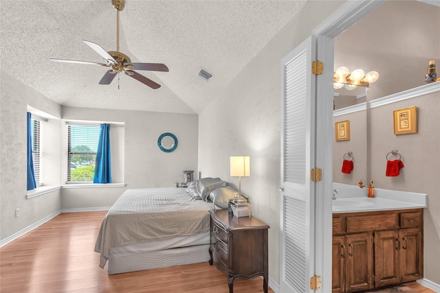2135 Rose Cliff Ln, Carrollton, TX 75007 - bedroom with a textured ceiling, lofted ceiling, light wood-type flooring, a sink, and ceiling fan