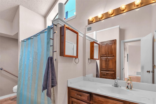 2135 Rose Cliff Ln, Carrollton, TX 75007 - bathroom with toilet, vanity, curtained shower, and a textured ceiling