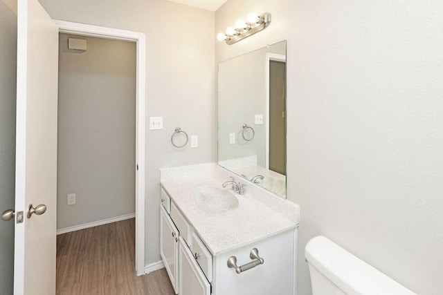 5907 Cohoke Dr, Arlington, TX 76018 - bathroom featuring vanity, wood finished floors, baseboards, and toilet