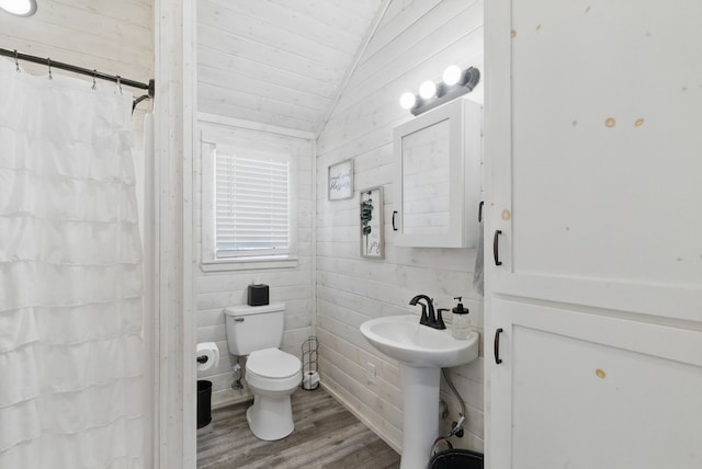 18230 Interstate 20, Cisco, TX 76437 - bathroom featuring wood finished floors, toilet, lofted ceiling, curtained shower, and a sink