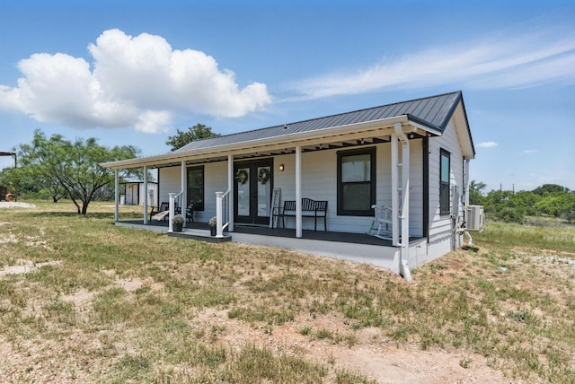 18230 Interstate 20, Cisco, TX 76437 - view of front of house featuring covered porch, metal roof, french doors, central air condition unit, and a front lawn