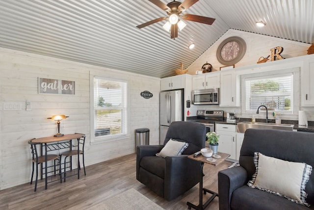 18230 Interstate 20, Cisco, TX 76437 - living room featuring healthy amount of natural light, ceiling fan, wooden walls, wood finished floors, and high vaulted ceiling