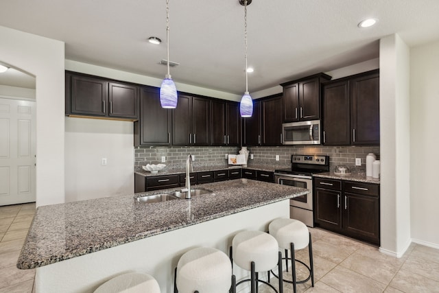 3740 Holly Brook Dr, Fort Worth, TX 76244 - kitchen featuring appliances with stainless steel finishes, a sink, dark stone countertops, backsplash, and dark brown cabinets