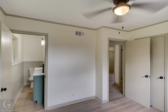 808 E St, Minden, LA 71055 - unfurnished bedroom featuring light wood-type flooring, crown molding, a closet, ceiling fan, and ensuite bathroom