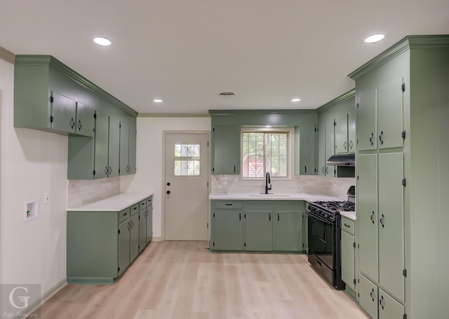 808 E St, Minden, LA 71055 - kitchen featuring black range with gas cooktop, tasteful backsplash, ornamental molding, light wood-style flooring, and under cabinet range hood