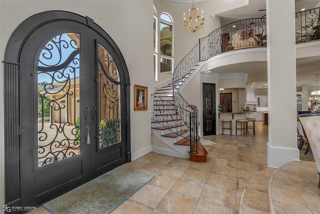 609 Enchanted Ln, Bossier City, LA 71111 - foyer entrance with arched walkways, a chandelier, baseboards, a towering ceiling, and french doors