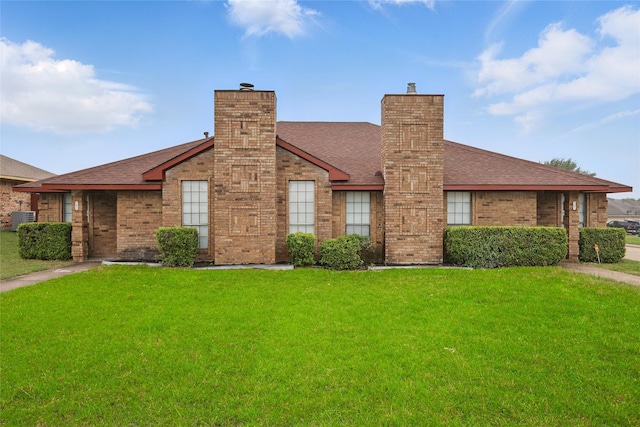 703 Inglewood Trl, Desoto, TX 75115 - view of front of home featuring central AC unit, brick siding, a front lawn, a shingled roof, and a chimney