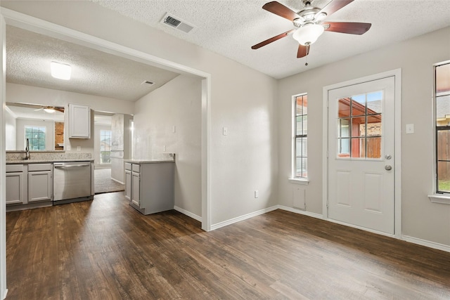 703 Inglewood Trl, Desoto, TX 75115 - kitchen featuring stainless steel dishwasher, ceiling fan, gray cabinetry, dark wood-style flooring, and a textured ceiling