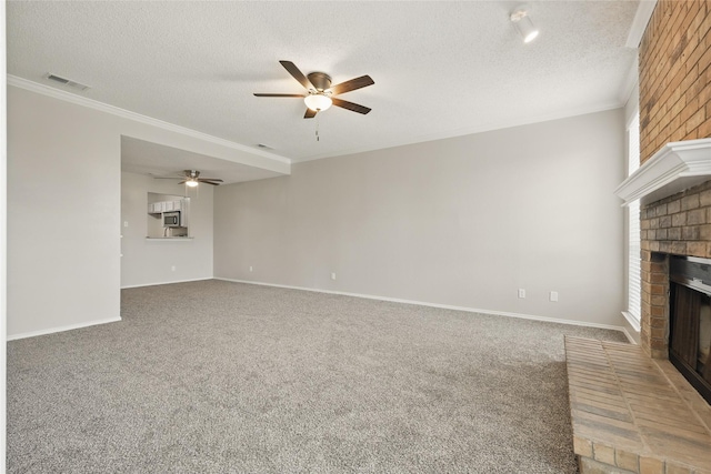 703 Inglewood Trl, Desoto, TX 75115 - unfurnished living room with a fireplace, a ceiling fan, ornamental molding, carpet floors, and a textured ceiling