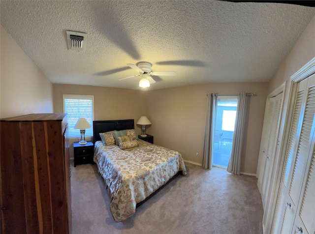 1308 Houston St, Sulphur Springs, TX 75482 - bedroom with light carpet, multiple closets, a textured ceiling, baseboards, and a ceiling fan