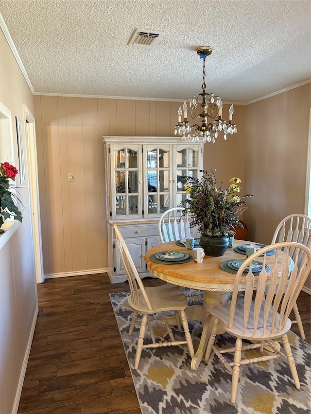 1308 Houston St, Sulphur Springs, TX 75482 - dining area featuring a chandelier, a textured ceiling, ornamental molding, dark wood-style floors, and baseboards