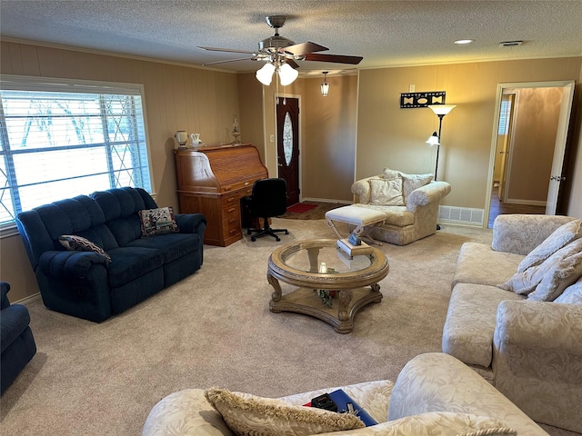 1308 Houston St, Sulphur Springs, TX 75482 - living room with ornamental molding, a textured ceiling, a ceiling fan, carpet, and wood walls