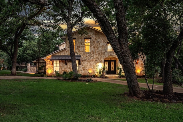 6501 Hillcrest Rd, Flower Mound, TX 75022 - view of front of home with stone siding, a yard, a standing seam roof, and curved driveway