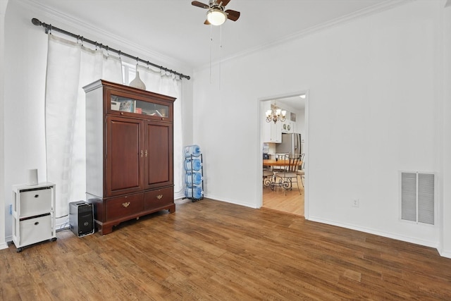 4516 Ridgepointe Dr, The Colony, TX 75056 - spare room with ceiling fan, wood finished floors, a chandelier, baseboards, and crown molding