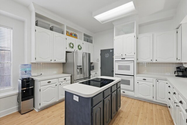 4516 Ridgepointe Dr, The Colony, TX 75056 - kitchen with stainless steel refrigerator with ice dispenser, black electric stovetop, white double oven, and white cabinetry