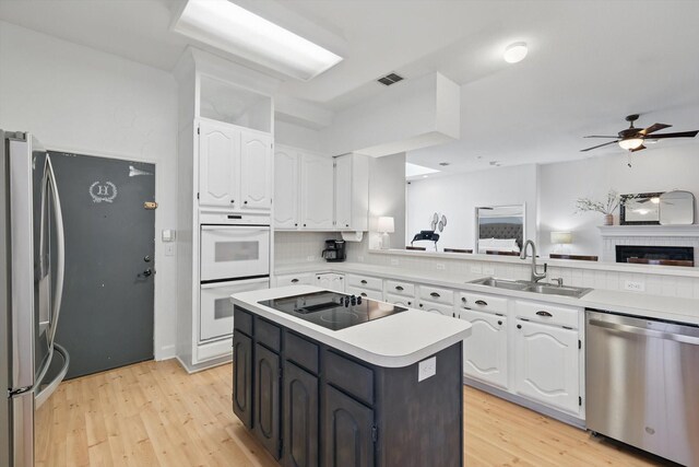 4516 Ridgepointe Dr, The Colony, TX 75056 - kitchen featuring stainless steel appliances, a sink, white cabinetry, a ceiling fan, and light countertops