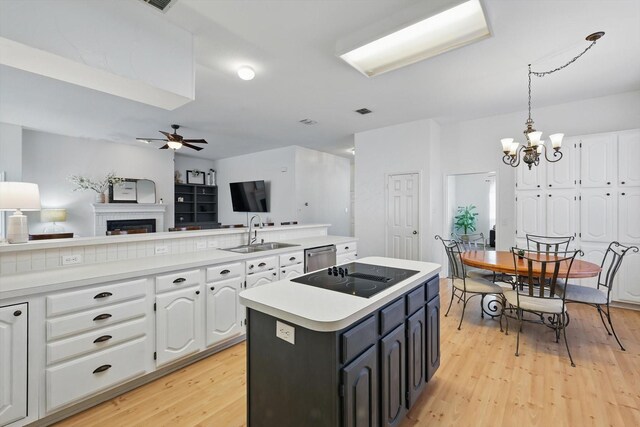 4516 Ridgepointe Dr, The Colony, TX 75056 - kitchen featuring a sink, black electric stovetop, ceiling fan, white cabinetry, and a chandelier
