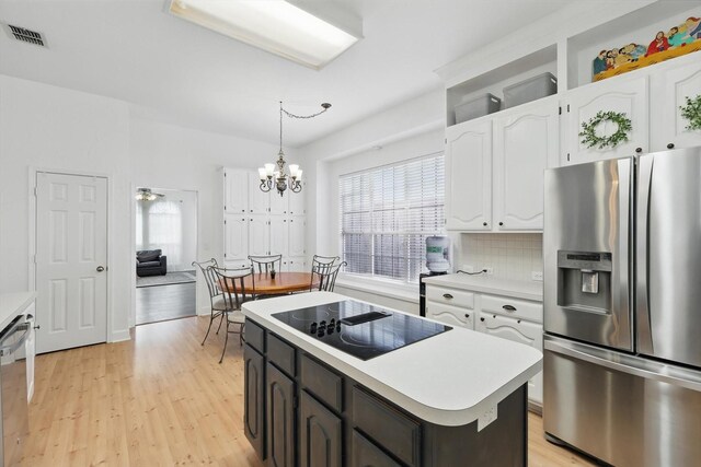 4516 Ridgepointe Dr, The Colony, TX 75056 - kitchen featuring stainless steel appliances, white cabinetry, a chandelier, and light wood-type flooring