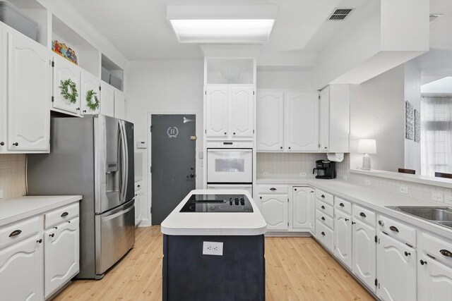 4516 Ridgepointe Dr, The Colony, TX 75056 - kitchen featuring black electric stovetop, stainless steel fridge with ice dispenser, white cabinetry, and decorative backsplash