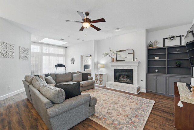 4516 Ridgepointe Dr, The Colony, TX 75056 - living room with a ceiling fan, dark wood finished floors, a fireplace, baseboards, and a skylight